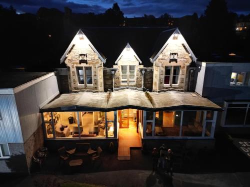 a house at night with people walking in front of it at The Acarsaid - Pitlochry in Pitlochry