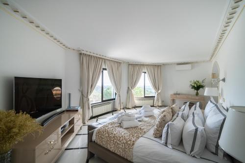 a bedroom with a large bed and a flat screen tv at Luxury Villa with SPA in Golfe-Juan - Sea View in Vallauris