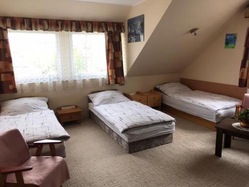 1 dormitorio con 2 camas y ventana en Luca Apartman en Esztergom