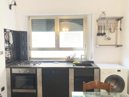 kuchnia ze zlewem, kuchenką i oknem w obiekcie Casa Dea a Marina di Cecina by Zoom In Earth w mieście Marina di Cecina