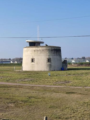 a building in the middle of a field at Awave From It All - Escape the city life in Jaywick Sands