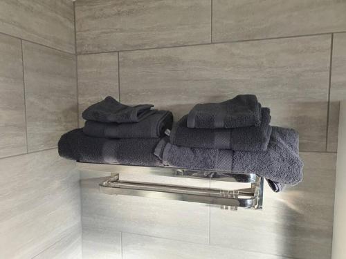 a group of towels sitting on a towel rack in a bathroom at Awave From It All - Escape the city life in Jaywick Sands