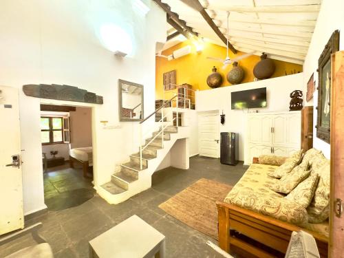 a living room with a couch and stairs in a room at Casa Da Praia in Candolim