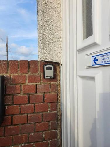 a brick wall with a door next to a building at Awave From It All - Escape the city life in Jaywick Sands