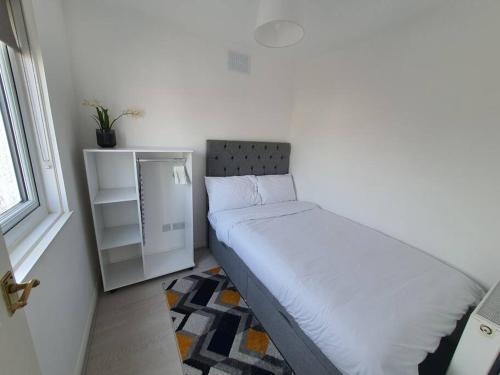 a small bedroom with a bed and a window at Awave From It All - Escape the city life in Jaywick Sands