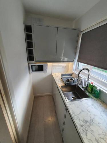 a small kitchen with a sink and a window at Awave From It All - Escape the city life in Jaywick Sands