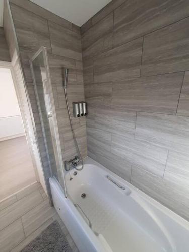 a bathroom with a white tub and a shower at Awave From It All - Escape the city life in Jaywick Sands
