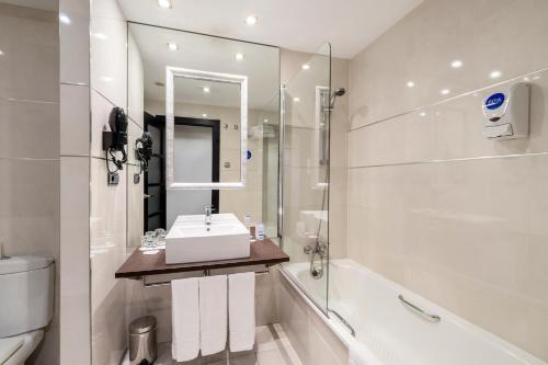 uma casa de banho com um lavatório, uma banheira e um WC. em Iberik Santo Domingo Plaza Hotel em Oviedo