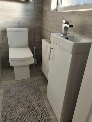 a bathroom with a white toilet and a sink at Awave From It All - Escape the city life in Jaywick Sands