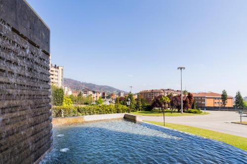 a swimming pool in the side of a brick wall at Iberik Santo Domingo Plaza Hotel in Oviedo