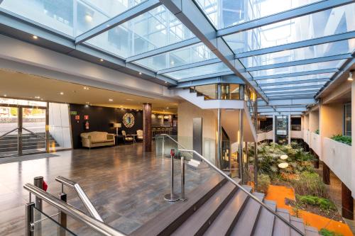 a lobby with a glass ceiling and a staircase at Iberik Santo Domingo Plaza Hotel in Oviedo
