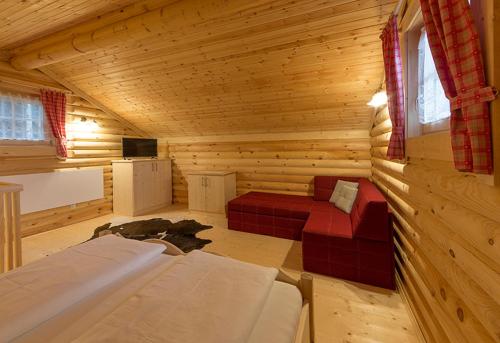 a log cabin with two beds and a tv at Anewandterhof in Brunico