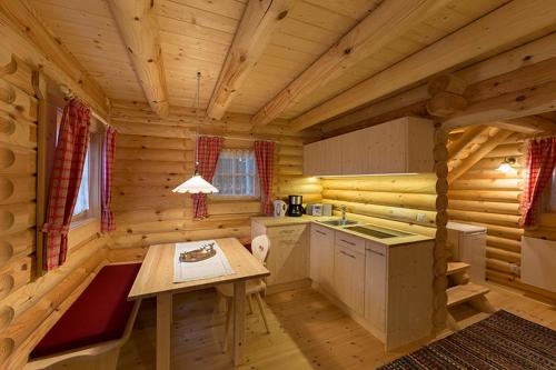 a kitchen with a table in a log cabin at Anewandterhof in Brunico