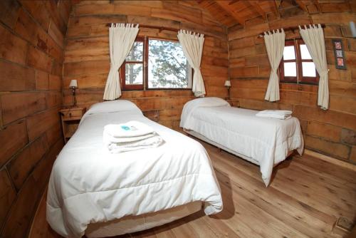 1 dormitorio con 2 camas en una cabaña de madera en Cabañas del Peñon 1 - 2 dorm en La Cumbrecita