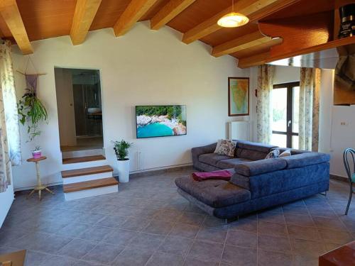 uma sala de estar com um sofá, uma mesa e escadas em House in Istria em Plomin