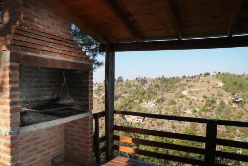 una chimenea de ladrillo con vistas a una colina en Cabañas del Peñon 1 - 2 dorm en La Cumbrecita