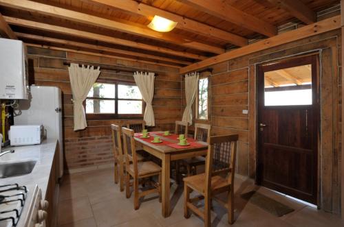 una cocina con mesa y sillas en una cabaña en Cabañas del Peñon 1 - 2 dorm en La Cumbrecita