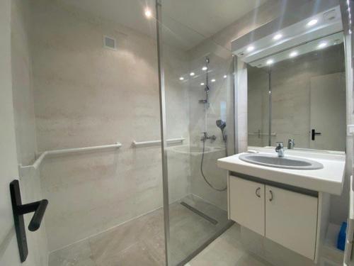 uma casa de banho com uma cabina de duche em vidro e um lavatório. em Appartement La Baule, 3 pièces, 4 personnes - FR-1-245-113 em La Baule