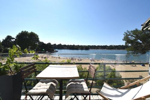 - une table et des chaises avec vue sur la plage dans l'établissement Cote d'argent - Hossegor en bordure du lac et à côté du joli parc, à Soorts-Hossegor