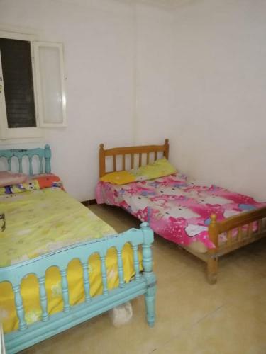2 Betten nebeneinander in einem Zimmer in der Unterkunft شقة مصيفية العجمى in Alexandria