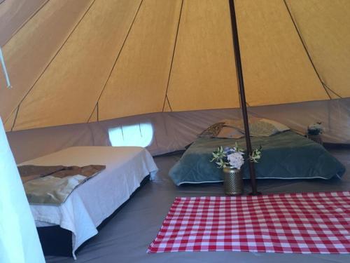 two beds in a tent with a red and white blanket at Glamping El Mirador de las estrellas in Bojacá