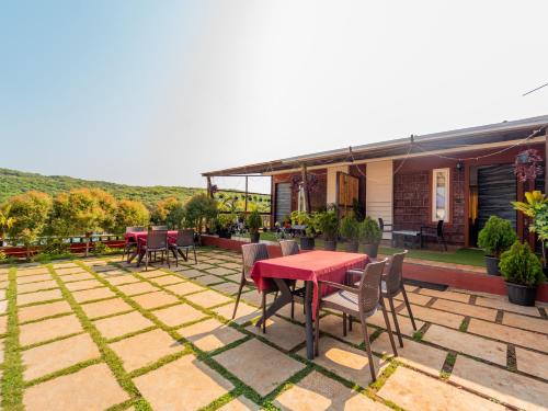 a patio with a red table and chairs at Red Button Resort in Mahabaleshwar