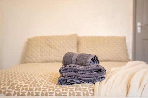 a pile of towels sitting on top of a bed at STAYZED G - Edge Of Nottingham City Centre NG7, Great Amenities & Transport Links - Ideal for Short & Long Stays in Nottingham