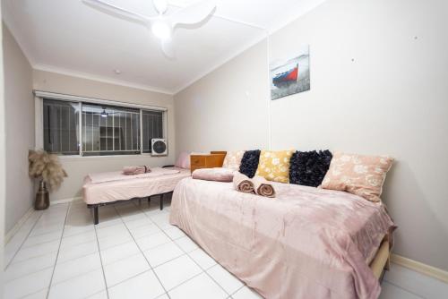 a bedroom with a bed and a couch and a window at Room in Shared Apartment U1M in Brisbane