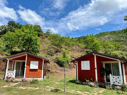 a small red house with a mountain in the background at Baven -Toven Naturae in Rubik