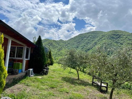 a house with benches in front of a mountain at Baven -Toven Naturae in Rubik
