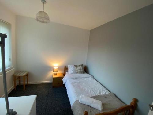 a small bedroom with a bed and a lamp at Spacious Luxurious Serviced Accommodation 3 in Warmsworth
