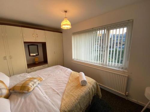 ein Schlafzimmer mit einem großen weißen Bett und einem Fenster in der Unterkunft Spacious Luxurious Serviced Accommodation 3 in Warmsworth