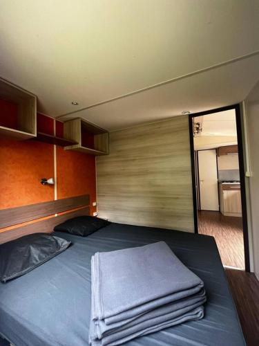 une chambre avec un lit avec une serviette dessus dans l'établissement Mobil Home Cosi Climatisé pour 6 - Camping Tohapi, à Vogelgrun