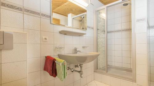 ein weißes Bad mit einem Waschbecken und einer Dusche in der Unterkunft Haus Gleinser - Neustift im Stubaital in Neustift im Stubaital