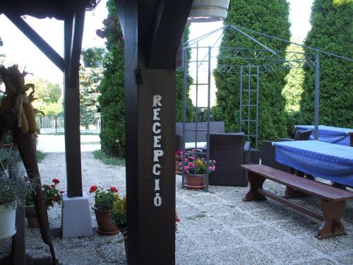 a patio with a bench and some plants and flowers at Krisztina Panzió in Balatonalmádi