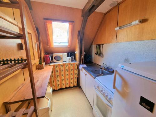 Elle comprend une petite cuisine équipée d'un réfrigérateur blanc et d'un évier. dans l'établissement Chalet cosy 6 pers. à Saint-Michel-de-Chaillol - balcon sud, 3 chambres, animaux admis - FR-1-393-128, à Saint-Michel-de-Chaillol