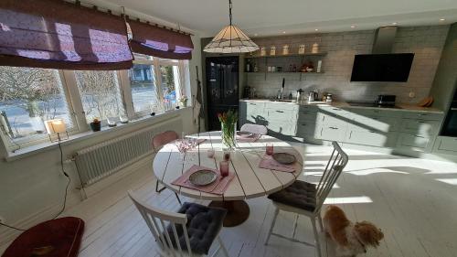 een keuken met een tafel en stoelen in een kamer bij Guesthouse Gärsnäs in Gärsnäs