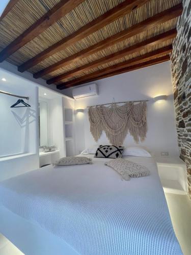 ein Schlafzimmer mit einem großen weißen Bett und einer Backsteinwand in der Unterkunft Psathi in Kythnos