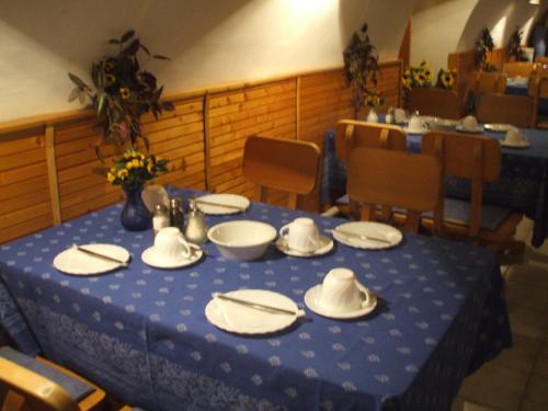 a blue table with white plates and hats on it at Krisztina Panzió in Balatonalmádi