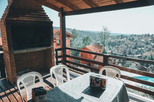 una mesa y sillas en un balcón con vistas en Cabañas del Peñon 2 - 2 dorm en La Cumbrecita