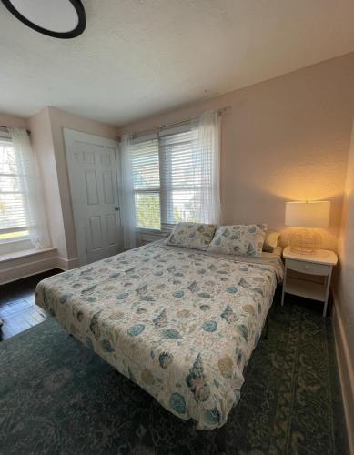um quarto com uma cama e duas janelas em The Blue Wave Suite Unit B em St. Petersburg