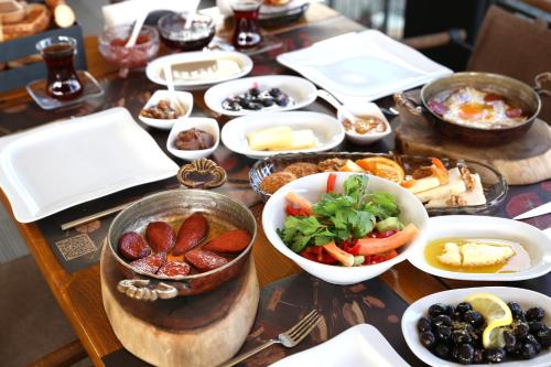 a table with plates of food and bowls of food at Dantela Butik Hotel in Cesme