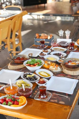 a table with many different dishes of food on it at Dantela Butik Hotel in Cesme