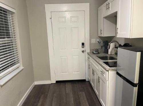 a kitchen with white cabinets and a white door at The Blue Wave Suite Unit C in St Petersburg