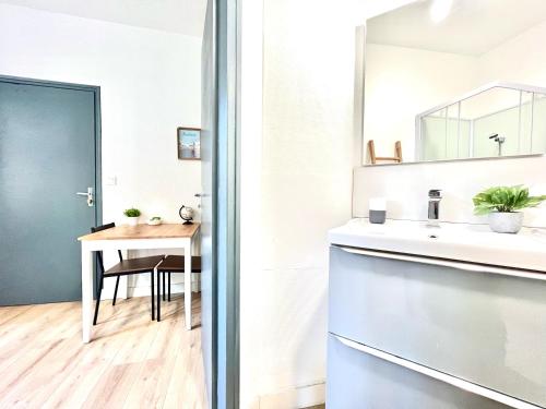 a bathroom with a sink and a table at Le Blossac, à 300m du centre ville - WIFI in Poitiers