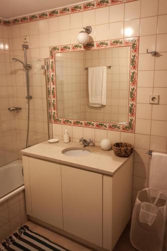 a bathroom with a sink and a mirror at Palácio da Quinta da Portela II in Coimbra