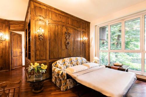 Klimt - Jacuzzi 5 Star - Luxury Design Apartment في ميلانو: غرفة نوم بسرير واريكة في غرفة