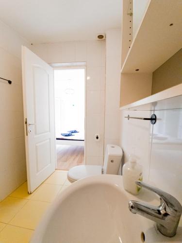 a white bathroom with a sink and a toilet at OZ Vacances in Vama Veche