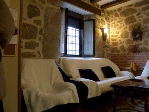 una sala de estar con 2 sillas blancas y una ventana en El Elaboratorio - casa Rural del siglo XVIII con piscina, en Villarejo del Valle
