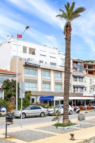 a palm tree in front of a building at Ufuk Otel in Cesme
